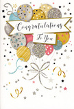 The photograph features a beautifully designed congratulations card, propped upright as though waiting to be slipped into a bouquet ready for delivery across Plaistow. The central artwork resembles a bouquet of balloons, gathered in a loose cluster that rises gently toward the top of the card. The balloons are rendered in a mix of understated, luxurious hues-champagne gold, cool silver, soft pink, calm sky blue, and misty grey-layered so that they overlap and create a sense of depth and softness. Each balloon carries its own personality through subtle patterns: delicate stars twinkling across some, neat stripes or glitter-like freckles adorning others. Metallic inks are used sparingly but effectively, lending a quiet sheen that suggests texture, as if you could trace the outlines with your fingertips. From the base of the balloons, slender metallic ribbons stream downwards in relaxed curls of gold and silver, meandering across the lower part of the design like strands of satin ribbon on a party table near Plaistow Park. Surrounding the main cluster, small metallic stars, swirling lines, and scattered confetti dots are sprinkled across the pale background, evoking the drift of confetti in the air and the gentle hum of a celebration. A wide, softly curved banner stretches through the middle of the composition, its shape cradling the central message. In graceful, looping script, the words Congratulations To You appear, the calligraphy adding a refined yet heartfelt touch. The overall mood is bright, polished, and warmly proud-an ideal card to accompany fresh flowers for any special achievement, from exam success to new beginnings, anywhere in the Plaistow area.