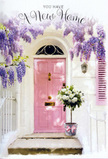 The photograph portrays a tenderly romantic entrance in Plaistow, where the simple act of arriving home is elevated by flowers and soft colour. A pale pink door sits at the centre, its muted tone giving it a calm, welcoming presence rather than a bold statement. The door is framed by whitewashed walls and a lightly coloured shutter, all bathed in soft daylight that might be late afternoon sun drifting over from the direction of Barking Road. Above and around the doorframe, wisteria cascades in lush streamers of lavender, lilac, and hints of dusky purple, each flower dangling in a loose, natural drape that blurs the architecture beneath. The wisteria's blossoms create a scented canopy, and its shadows dance across the panels and wall, adding depth and movement to the still image. Resting neatly at the doorstep, a grey metal bucket serves as a rustic vase for a cluster of white and cream roses. The roses are opulent yet understated, with velvety petals that open generously, revealing the soft folds at their centres. Intertwined among them are sprigs of quiet green foliage, which give the bouquet a balanced, garden-fresh character. Encircling the bucket is a satin ribbon in a gentle pink shade, tied with care and subtly shimmering as it catches the light, echoing the door's colour so the eye moves easily between flowers and entrance. The whole scene feels like a housewarming surprise arranged through Flower Delivery Plaistow, perfect for greeting someone returning to a new flat near Green Street or a terraced home by Plaistow Park. It carries the emotion of arrival, of keys exchanged and doors first opened, with every petal speaking of comfort, hope, and a heartfelt welcome home.